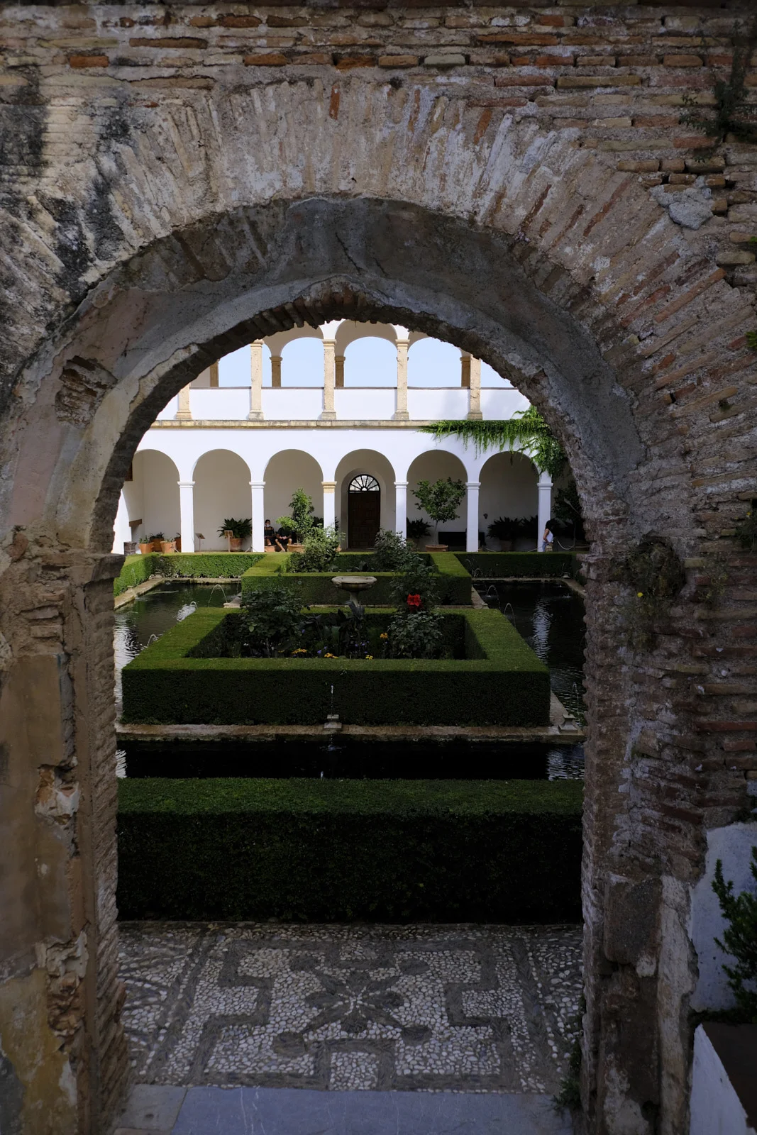 The Court of the Sultana's Cypress in the Generalife at Granada, seen through an arch.