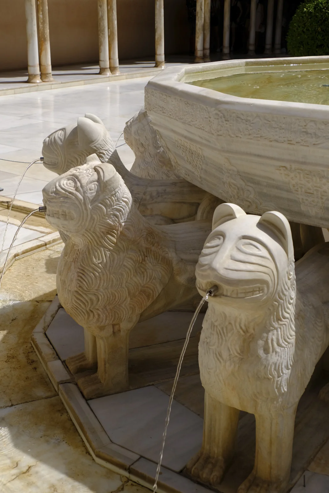 Stone lions stand under the fountain basin in the Court of the Lions, each with a spout at the mouth.