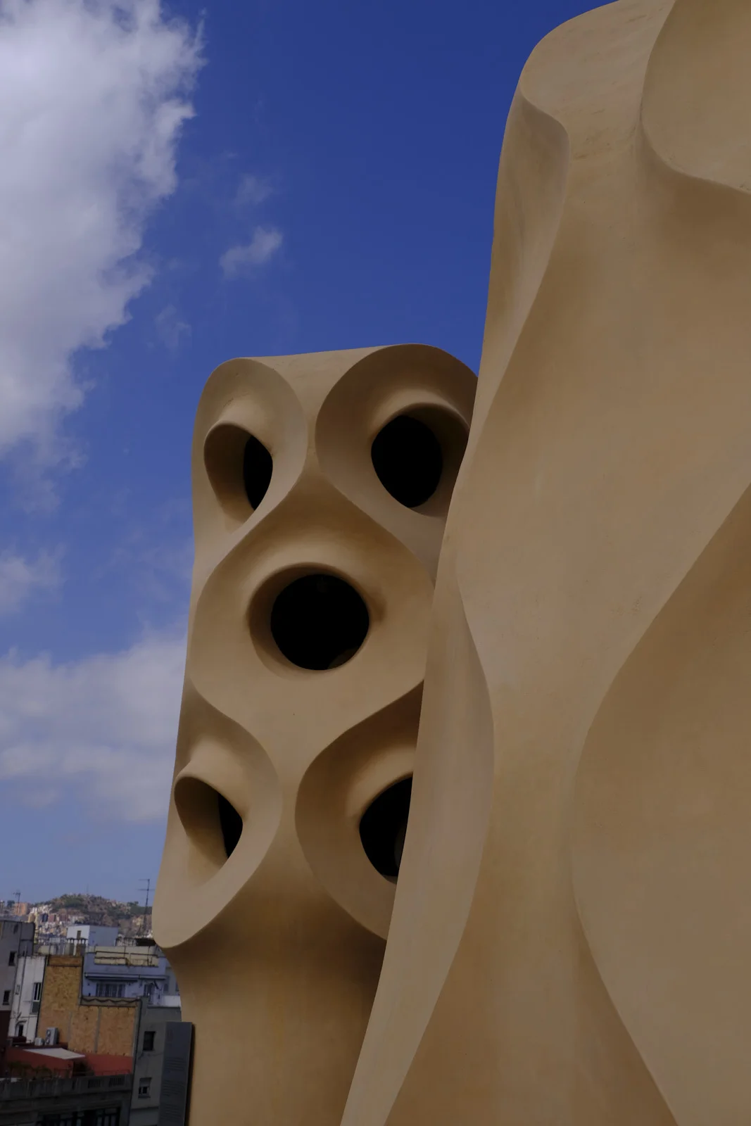 A roof structure pierced by oval openings stands on La Pedrera in Barcelona.