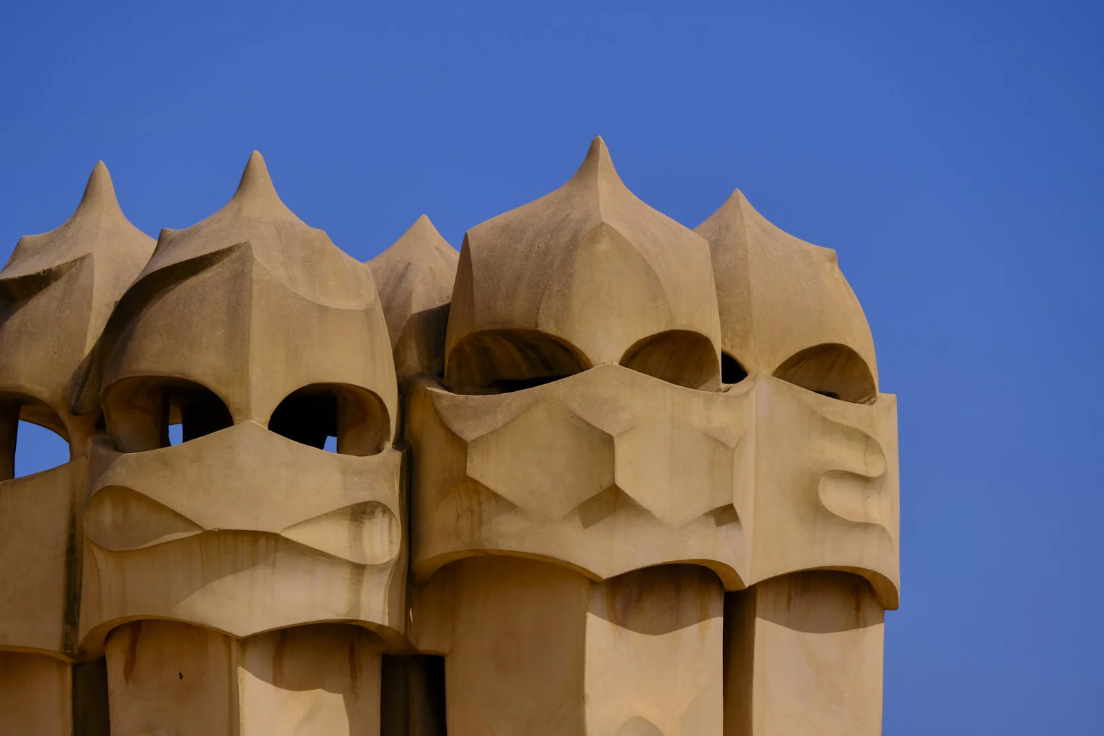 Helmet-shaped chimney pots with open vents stand on the roof of La Pedrera in Barcelona.
