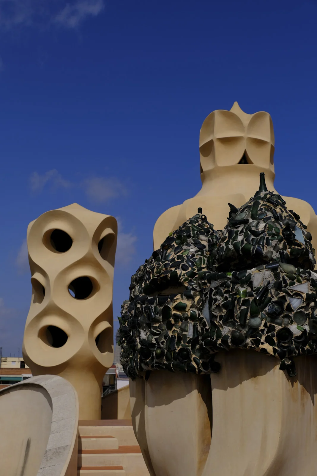 A chimney covered in broken glass stands among other roof forms on La Pedrera in Barcelona.