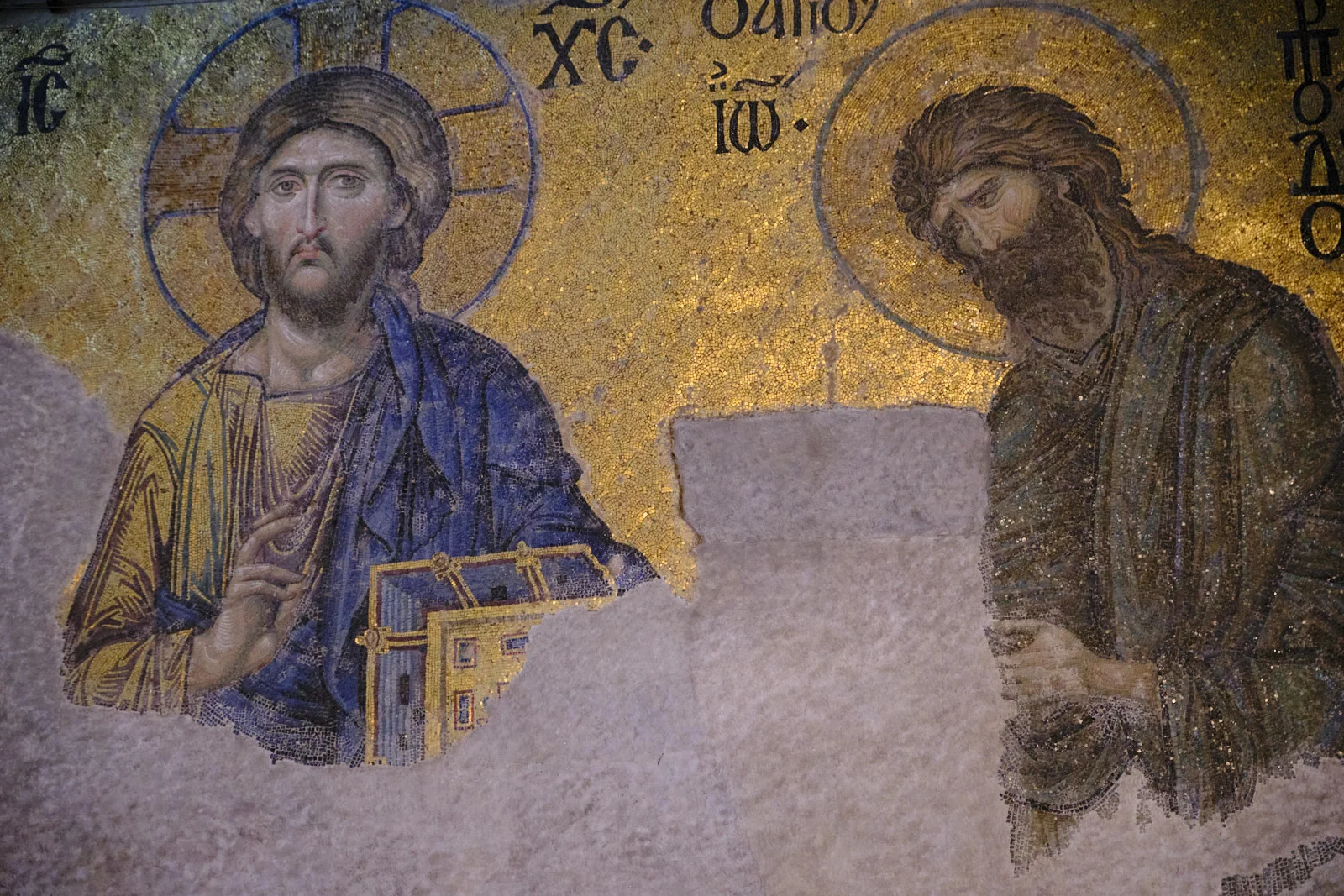 A gold mosaic in Hagia Sophia of Christ holding a book beside the bowed figure of John the Baptist, with a large area of missing plaster between them.